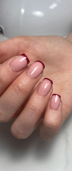 A hand with multicoloured french tip nail art 