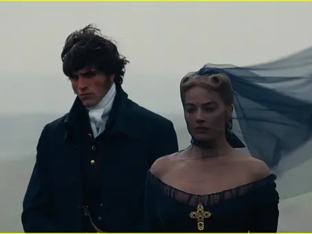 Two people in 19th-century attire stand on a misty plain. The woman's veil flows in the wind; both appear somber.