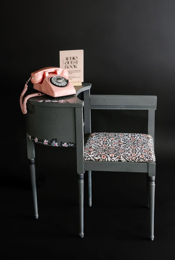Dark setting features a vintage pink rotary phone on a gray floral-patterned chair with "Audio Guest Book" text. Elegant and nostalgic.