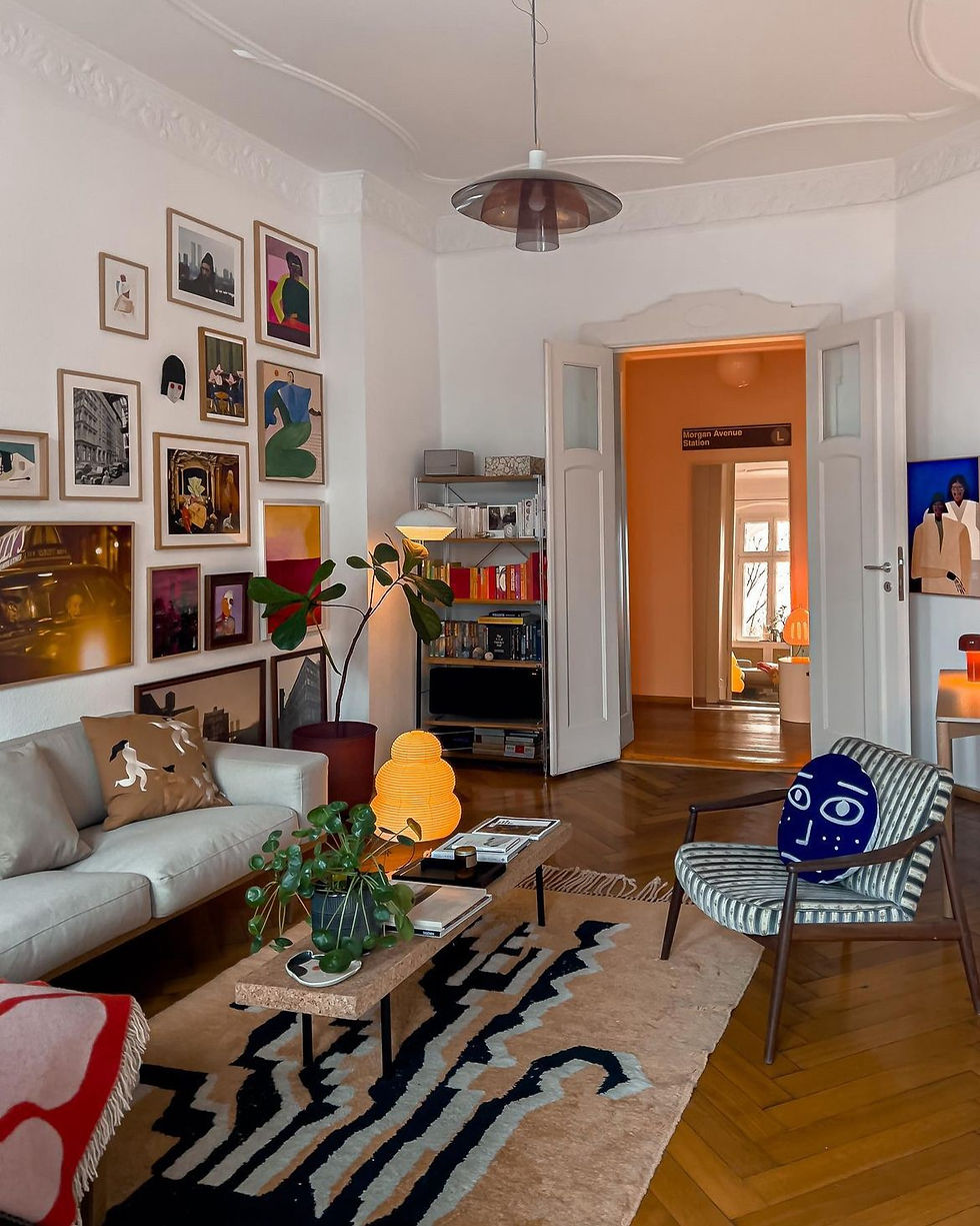 Cozy and eclectic living room of Sofia Noriega, showcasing an IKEA MARKFROST Table Lamp and a Morgan Avenue Station sign, surrounded by an array of colorful artwork and modern furnishings.