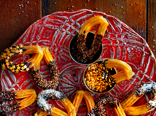 festligt strösslade churros på ett rött julfat som julgodis efterrätt