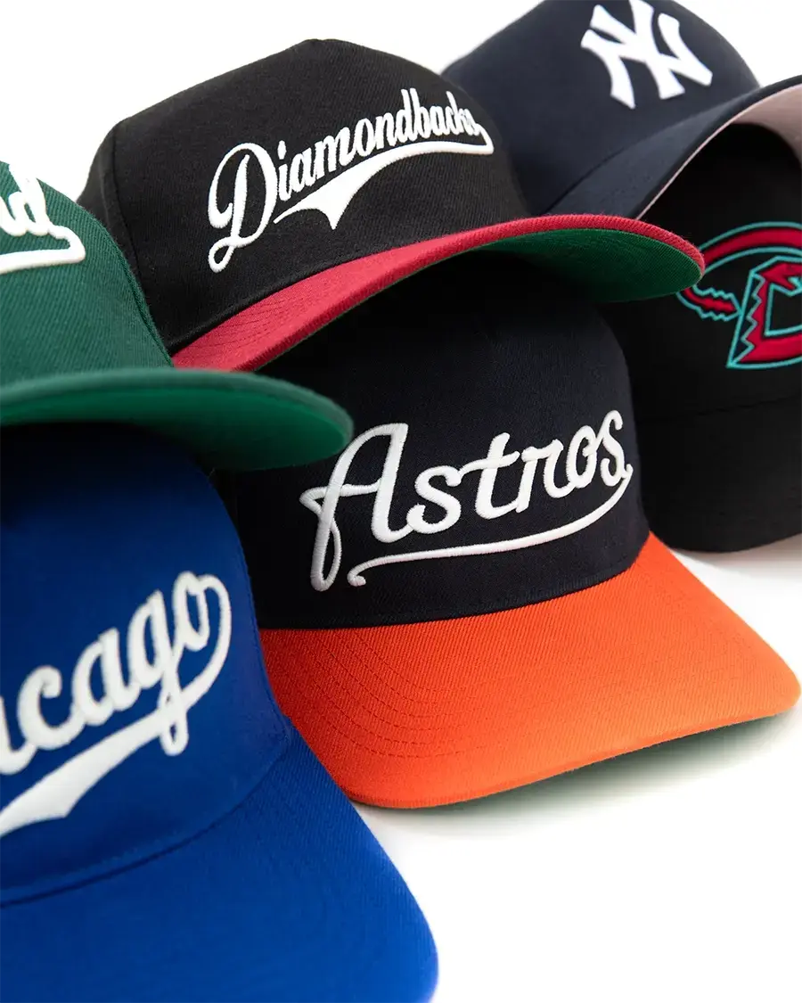 Assorted MLB snapback hats with embroidered team logos, featuring bold colors and classic flat-brim styles from Hat Club