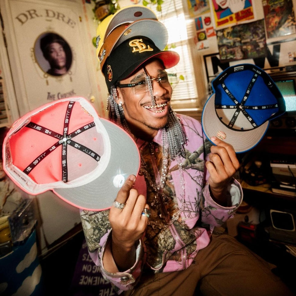 Smiling collector wearing stacked fitted hats and holding two New Era caps, showing inside details and vibrant colors from Hat Club.