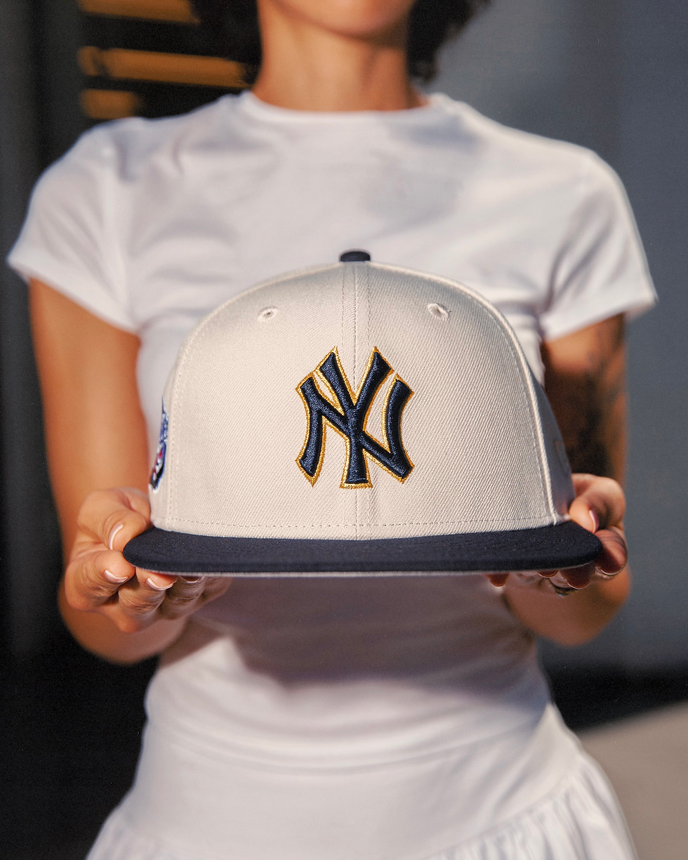 Cream New York Yankees fitted cap with navy brim, premium embroidery, displayed by model for Hat Club exclusive headwear
