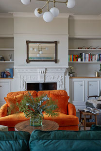 Lounge space with bespoke shelving joinery and funky rust sofa