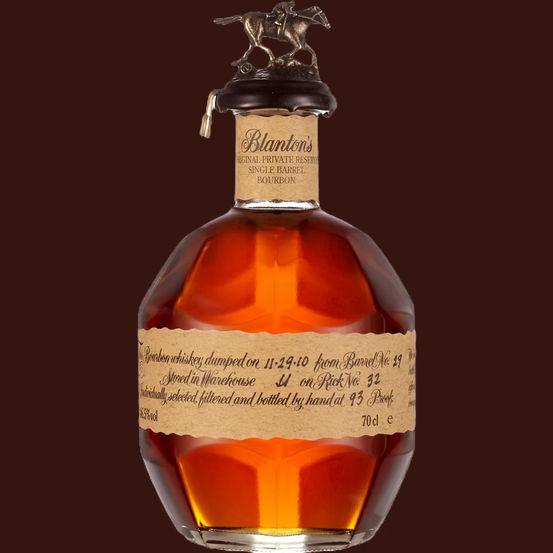 A beautifully crafted bottle of Blanton’s Original Single Barrel Bourbon, featuring an elegant horse and jockey topper, showcases its amber-hued spirit and artisanal attention to detail with a handwritten label.