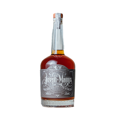 Bottle of Joseph Magnus whiskey with ornate label, amber liquid, and silver neck wrap.