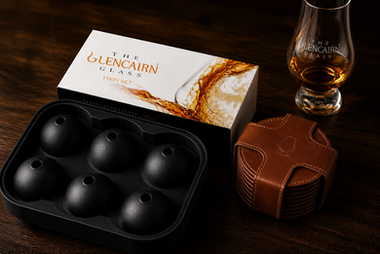 Enhance your bourbon experience with top-notch accessories: Glencairn glasses, a sleek ice mold, and elegant leather coasters.