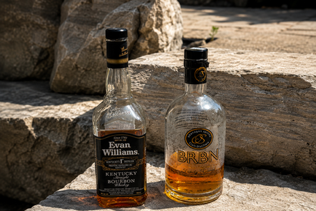 Two whiskey bottles on sunlit stone steps, Evan Williams and BRBN labels visible, with warm amber liquid inside.