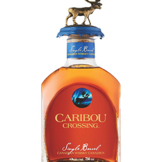 Bottle of Caribou Crossing single barrel Canadian whisky with moose topper, amber liquid, black background and label text.