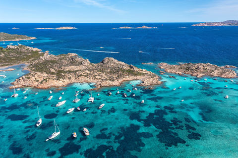 Aerial view of Passo del Topo on Santa Maria Island, with rugged coastline and boats anchored nearby