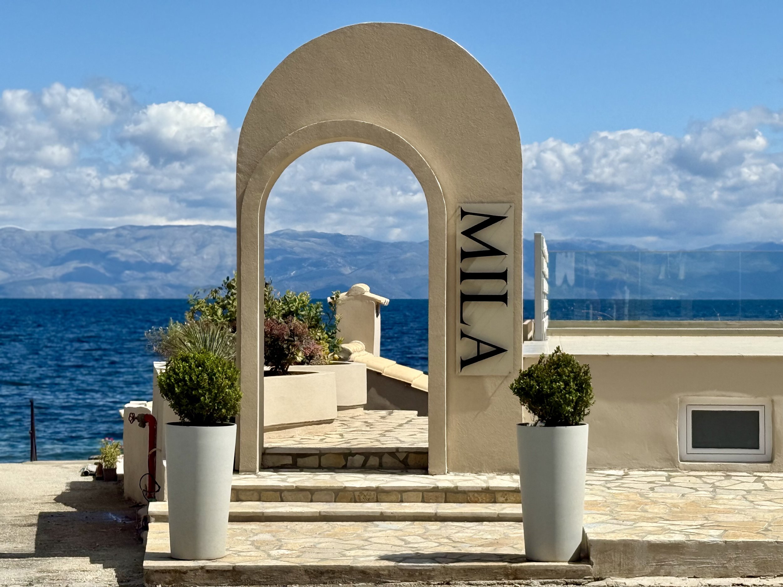 MILA Restaurant & Beach Lounge entrance overlooking the sea in Benitses, Corfu