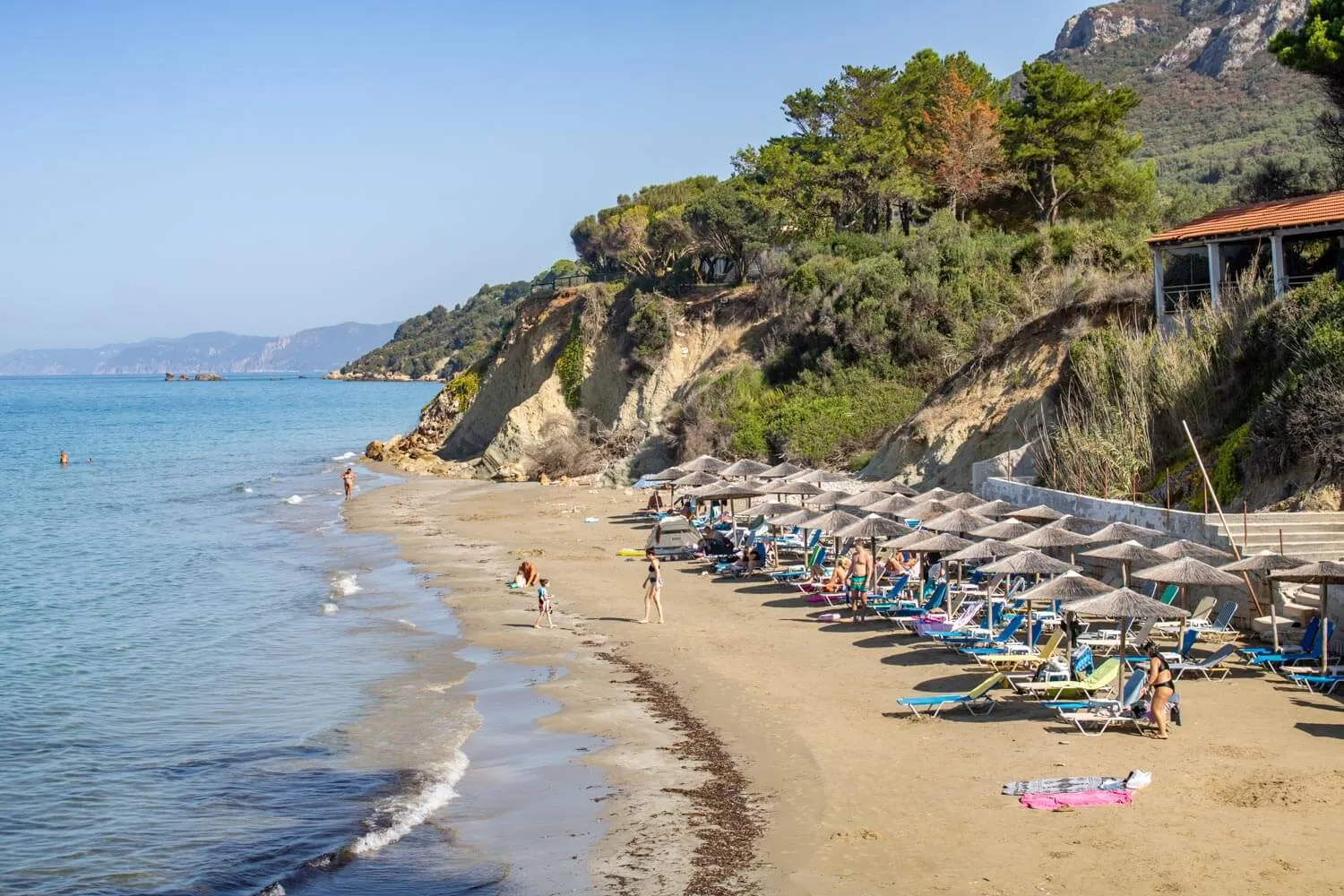 Only the southern cove is organised with seasonal sunbeds and parasols; the northern stretch remains undeveloped.