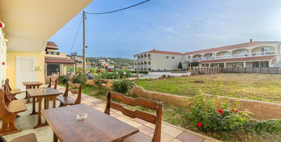 Terrace and accommodation buildings at Kosmos Hotel in Agios Stefanos Avliotes, Corfu