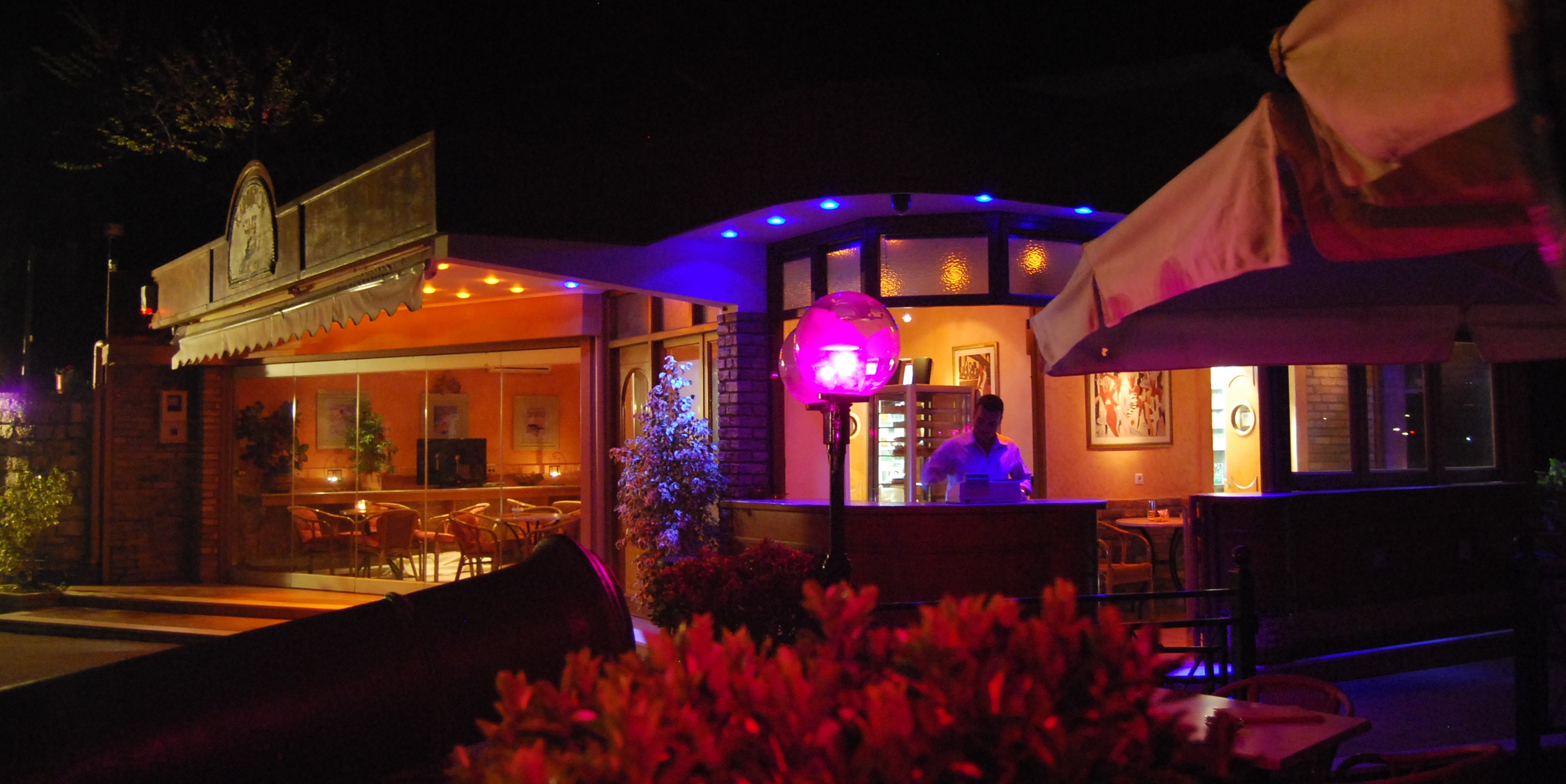 Cafe Kanoni illuminated at night in Kanoni, Corfu