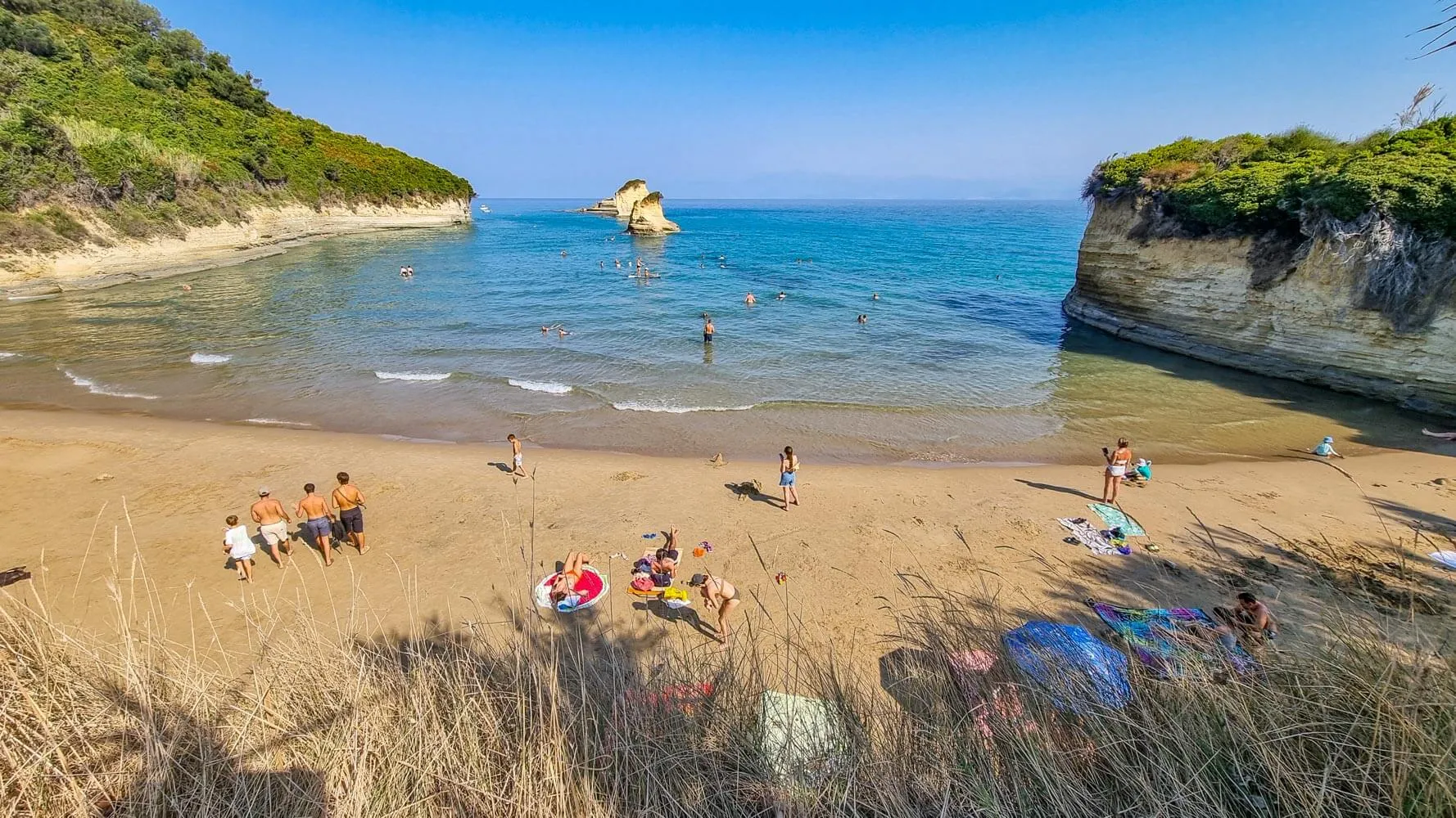 There is no dependable full beach sunbed service. A few loungers may occasionally be associated with the nearby bar, but visitors should be prepared to use towels and bring their own shade.