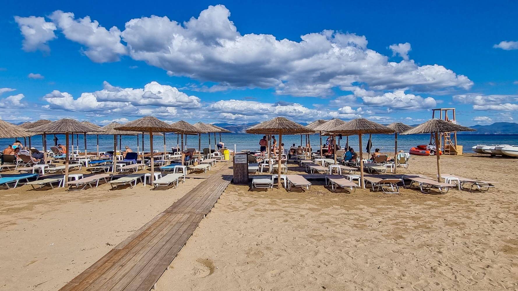 Only the northern section near the Lefkimmi River is organised with seasonal sunbeds and parasols; most of the long beach remains open.