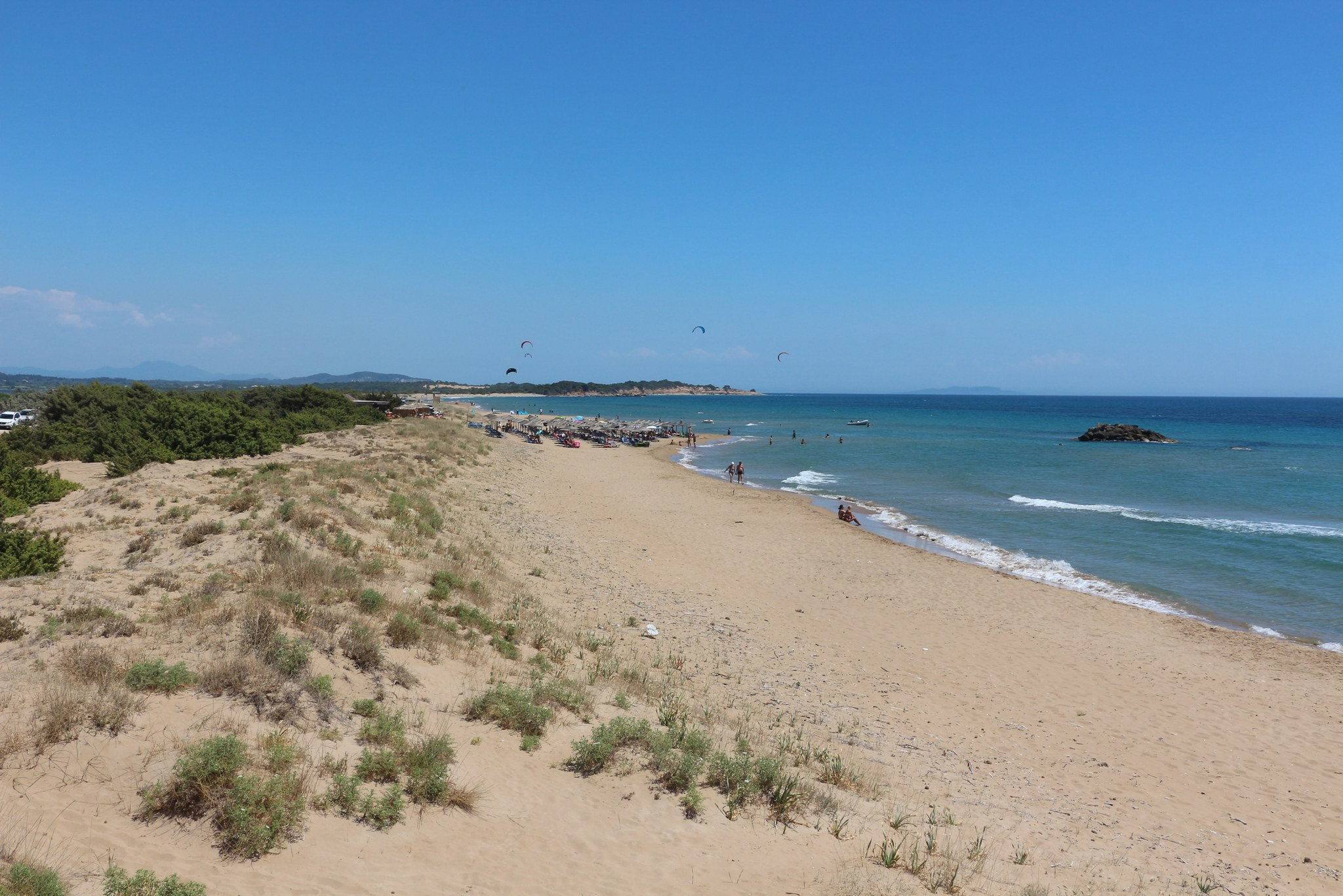 Only a small central section is organised with seasonal sunbeds and parasols; most of the beach remains open and natural.