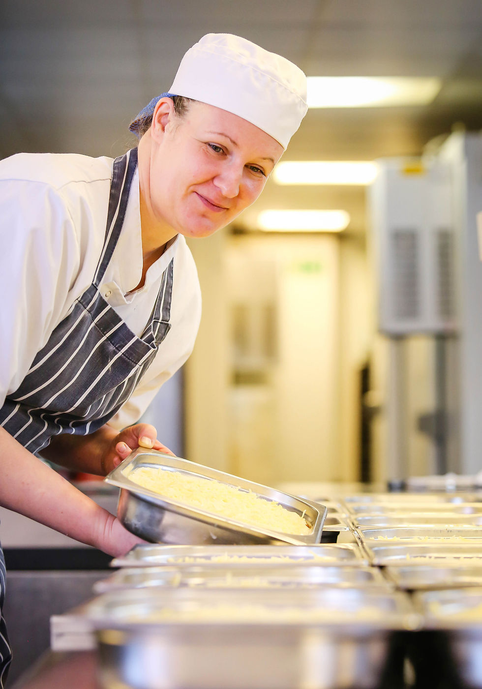 A female chef lifting up a food container