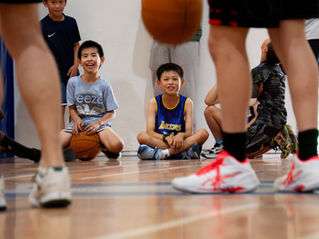 boys watching people play basketball