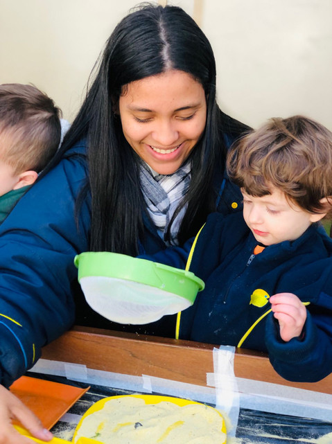 professora e menina brincando com fubá
