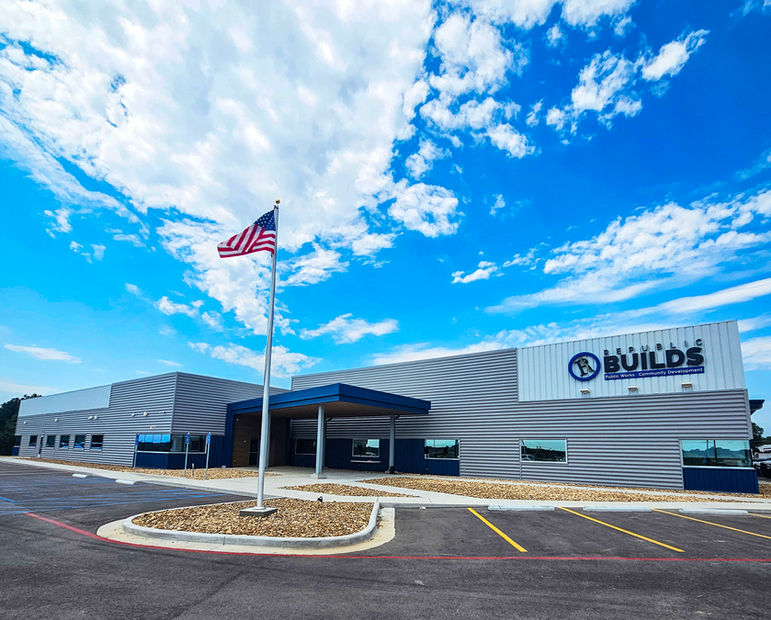 Exterior photo of warehouse and office space with a blue sky in the background and an American flag flying in the foreground.