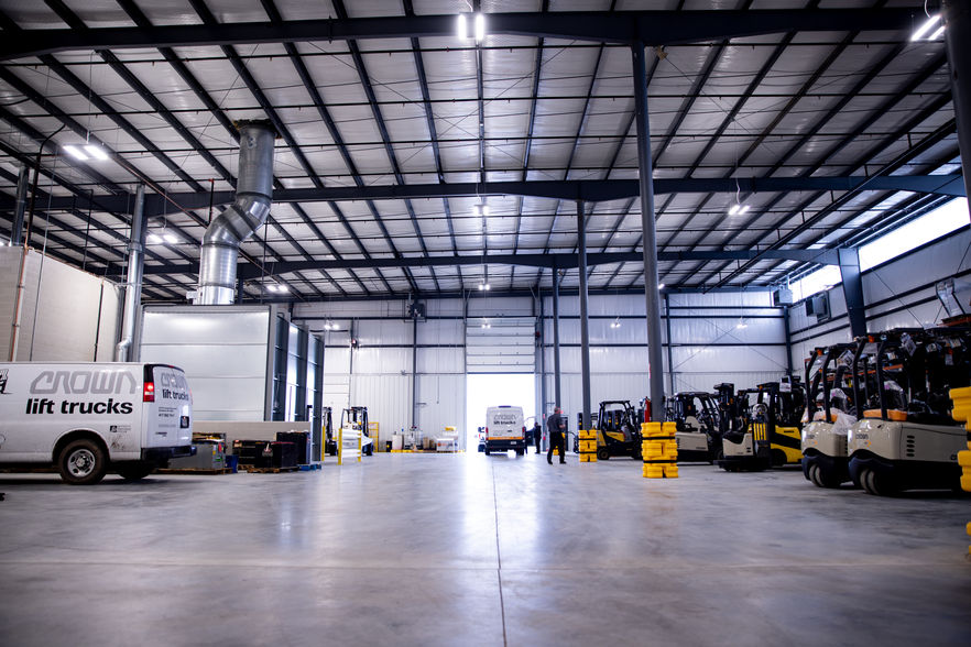 Alternate Crown Trucking Warehouse Interior. Shows open steel interior, steel support beams and the warehouses trucks and packages.