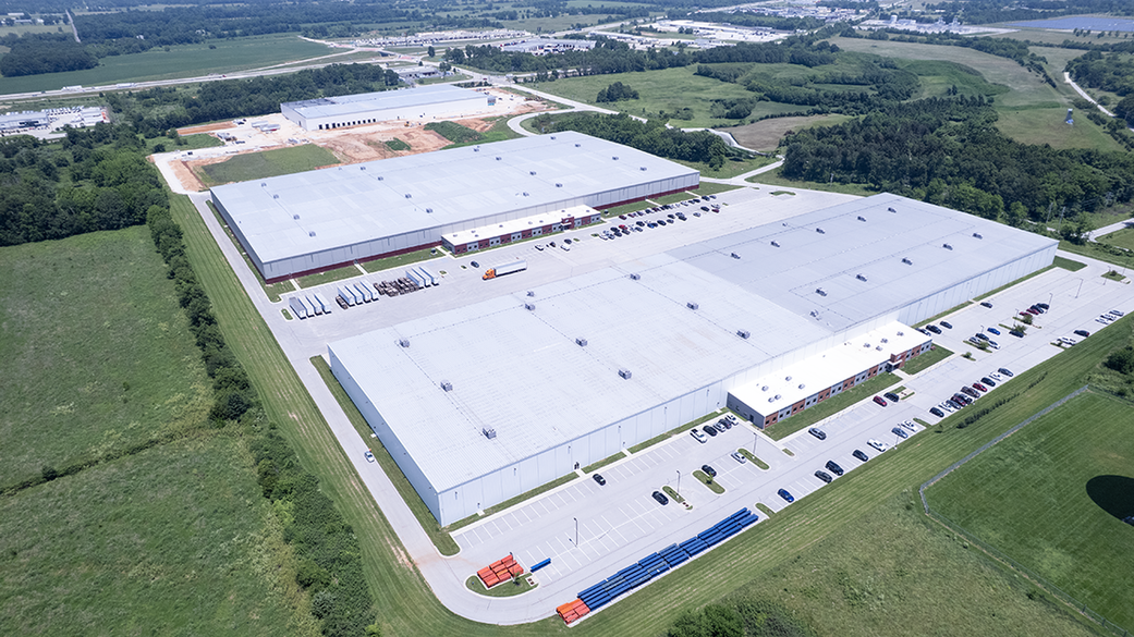 Drone photo of three white warehouse buildings.