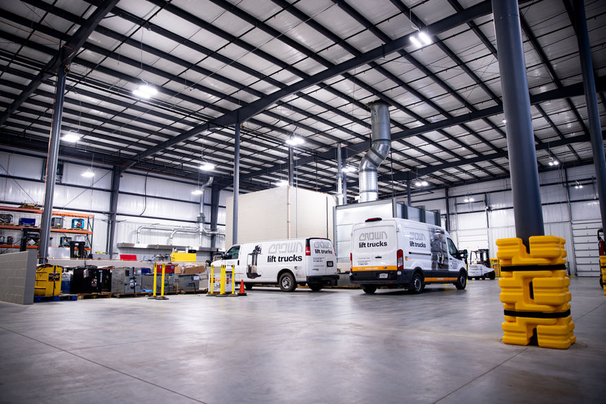 CrownTrucking Warehouse Interior. Shows open steel interior, steel support beams and the warehouses trucks and packages.