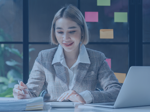 Young business woman checking paperwork from accounting department to analyse number on document, using computer laptop to check database