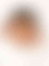 A cozy, minimalistic newborn photography session featuring a baby peacefully sleeping in a soft, neutral-toned wrap, placed on a textured blanket.