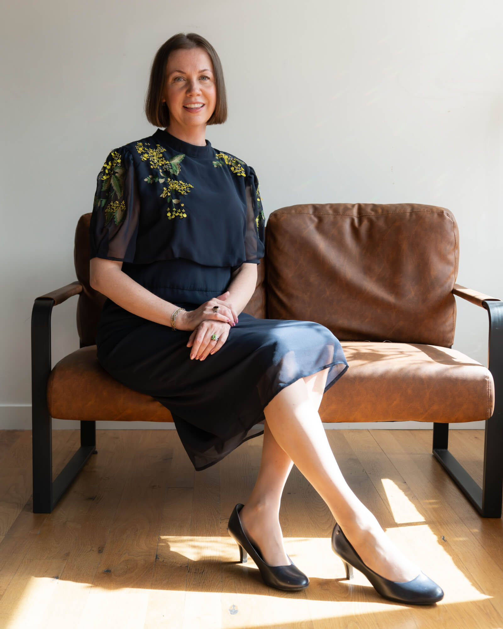 Andrea Rees the Divorce Counseling in Idaho Falls, sitting on a bench holding her glasses