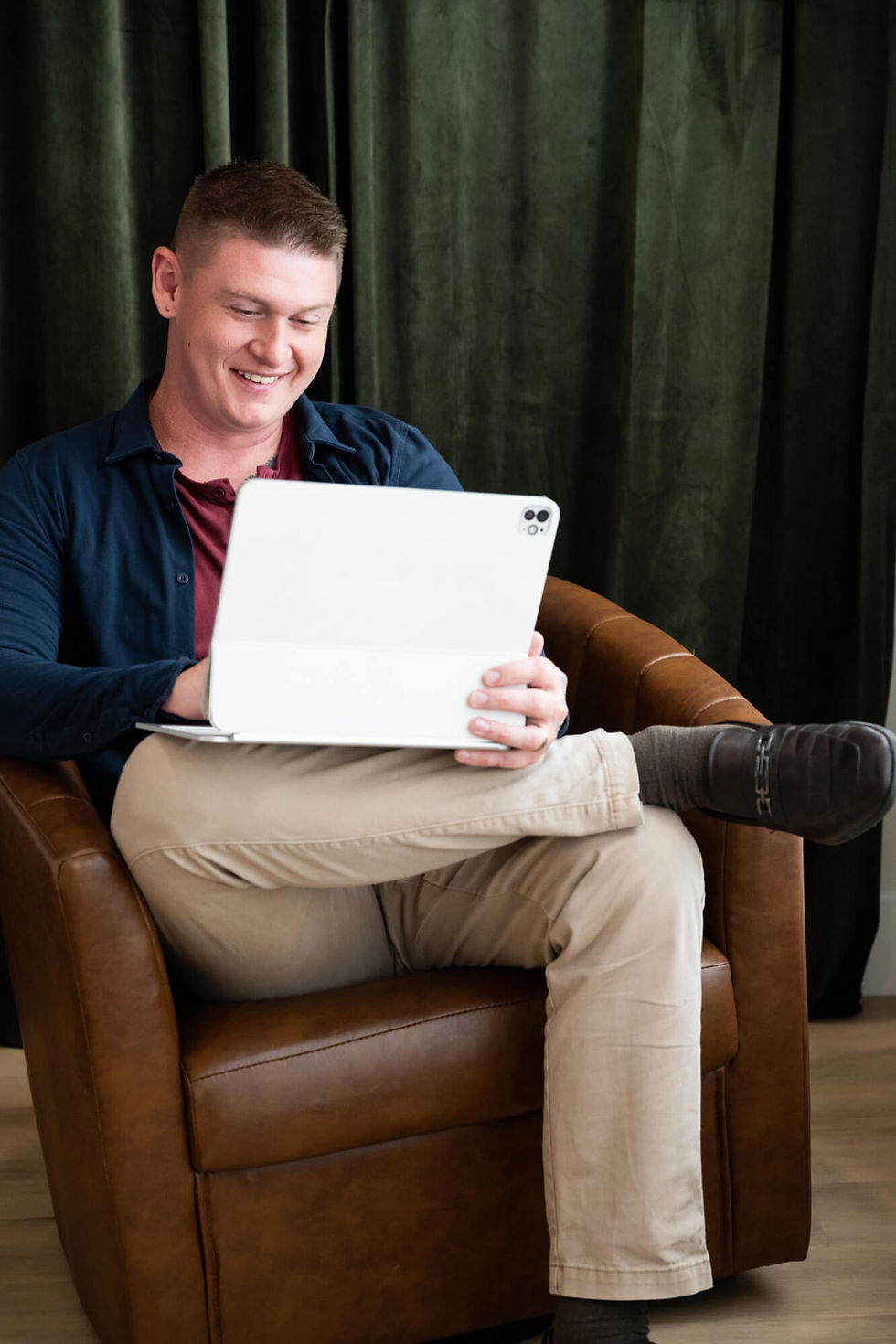 A businessman utilizing a creative lounge chair to get some work done on a laptop