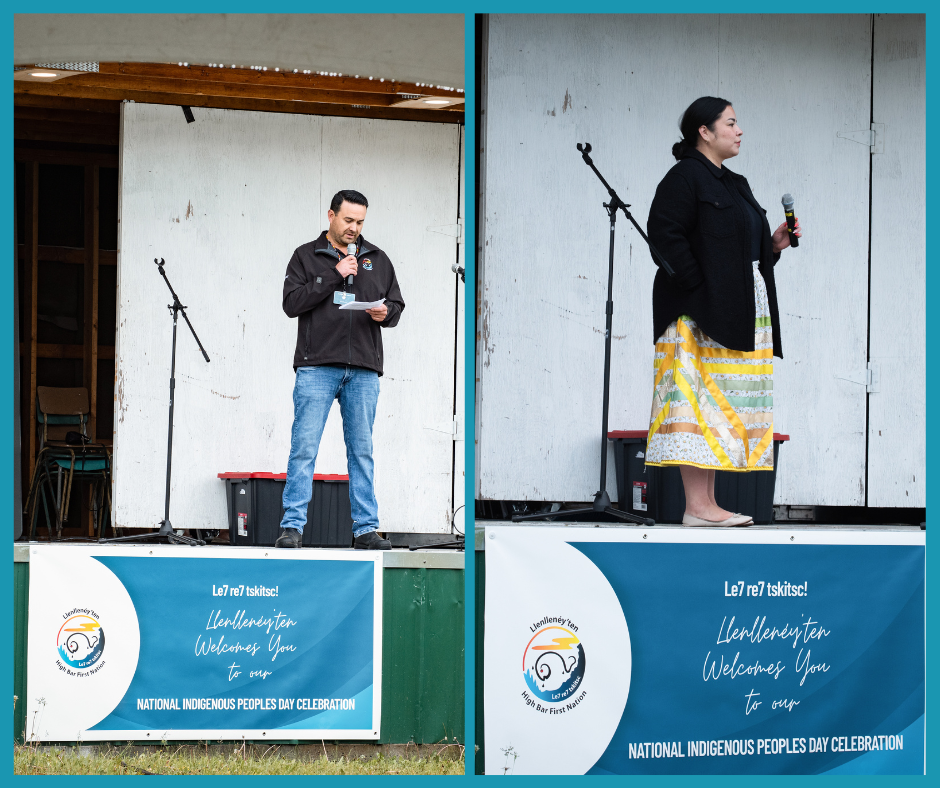 Two people speak on stage with microphones at National Indigenous Peoples Day. Background features a banner and wooden wall.