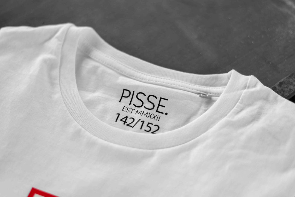 Miniaturbild: Nahaufnahme eines weißen Shirts für Kinder. Man sieht den Aufdruck der Marke "Pissepunkt".