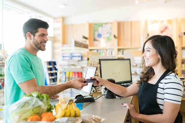 smiling-female-cashier-with-buyer-checkout-counter-grocery-store.jpg