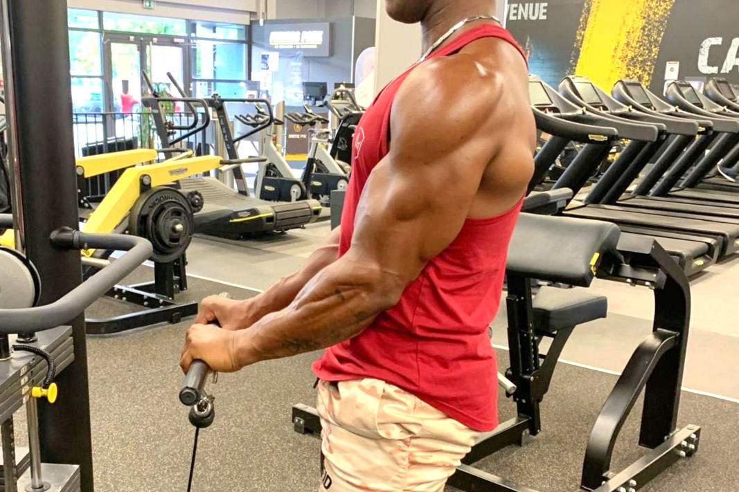 Bodybuilder travaillant la flexion de bras en pronation à la poulie basse