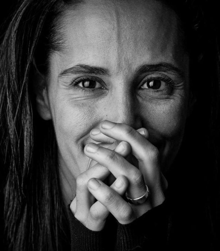 Portrait d'Amélie Lévy, ostéopathe D.O. au Grau-du-Roi, en noir et blanc, mains jointes devant le visage