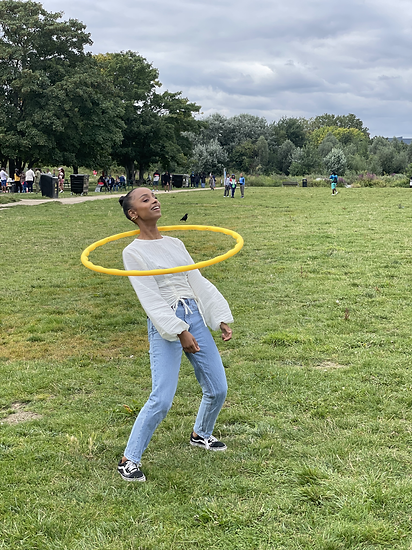 Black woman hula hooping in the park