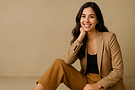 Smiling woman in a suit, sitting with a hand on her face. My Site 48