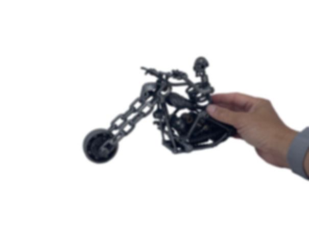 Recycled metal ghost rider style motorcycle sculpture shown in hand