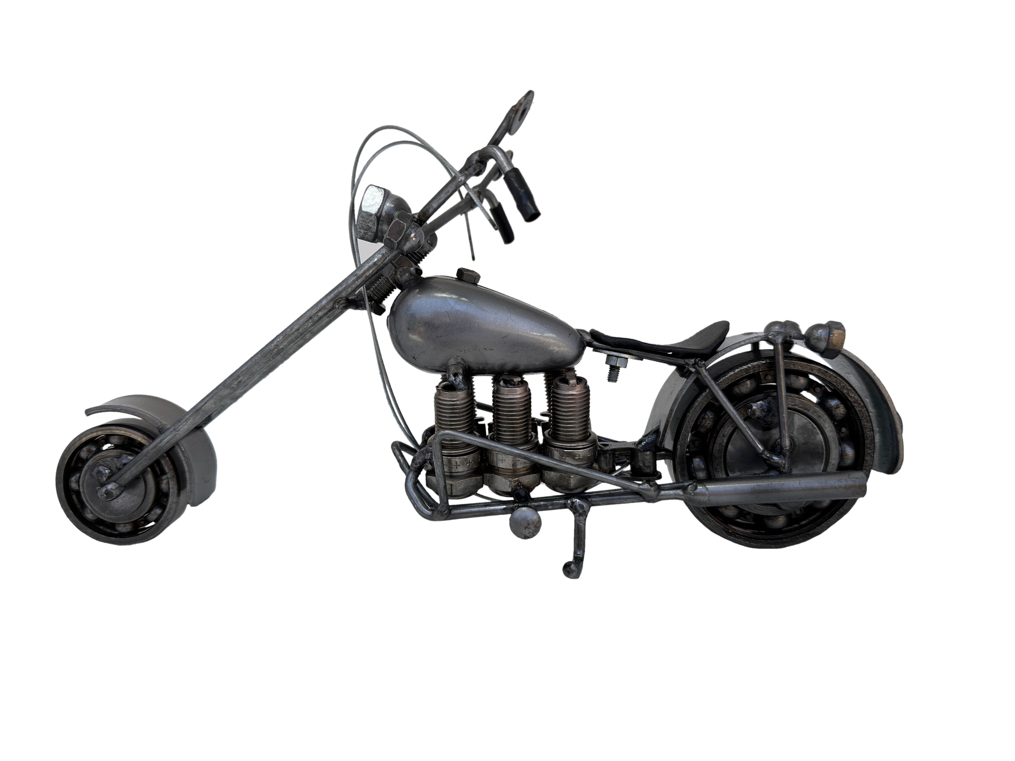 Six-cylinder recycled metal motorcycle sculpture handcrafted from steel parts, side view on white background