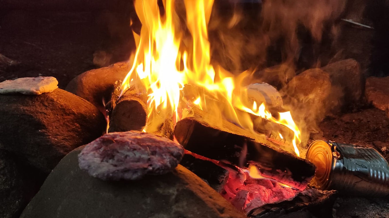 Eine Feuerstelle, mit einen Survival-Brot, das auf den heissen Steinen gart.