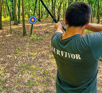Teilnehmer beim Survivaltraining mit Bogen im Wald – Zielübung im Outdoorcamp der Survivalschule Niedersachsen