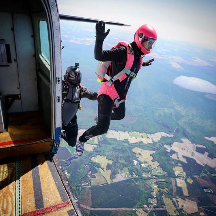 Woman skydiver exits plane during coach course