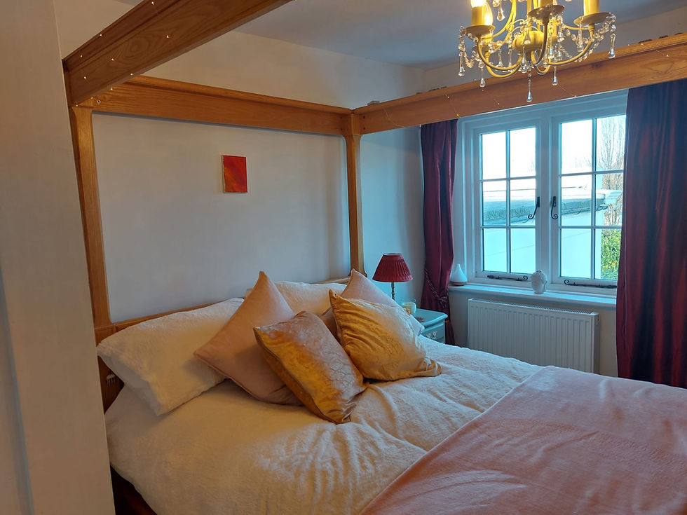 Cozy four-poster double bed with warm peach and gold bedding