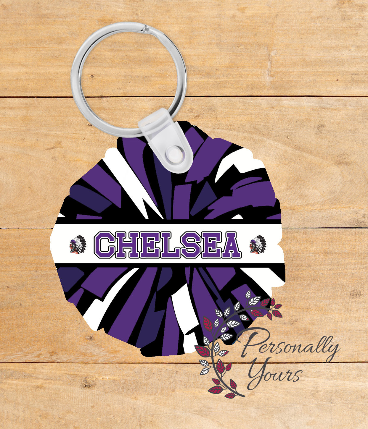 Purple and black pom pom shaped acrylic keychain with personalized name Chelsea and Warriors logo accents