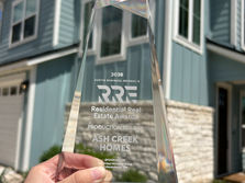 2026 RRE Award in front of Drew Lane Model Home