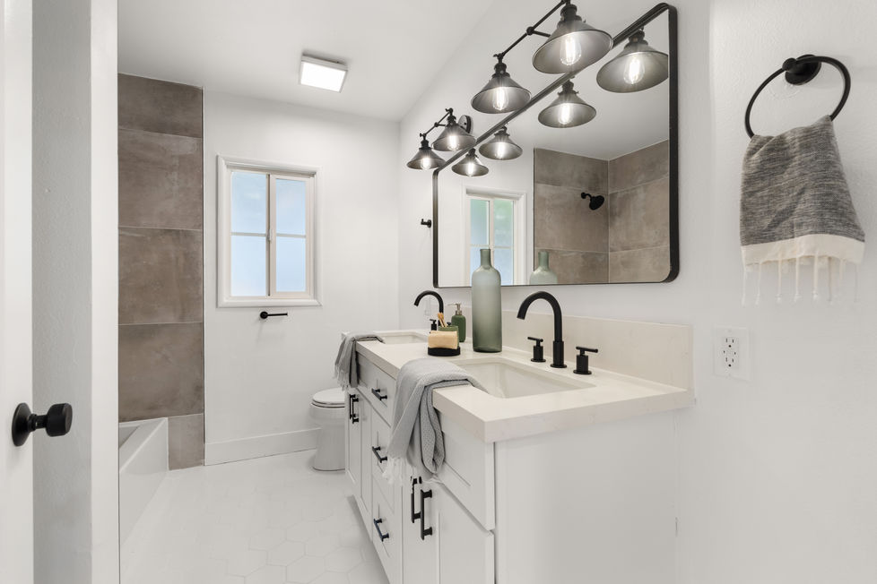 a bathroom with dual vanity, a large mirror