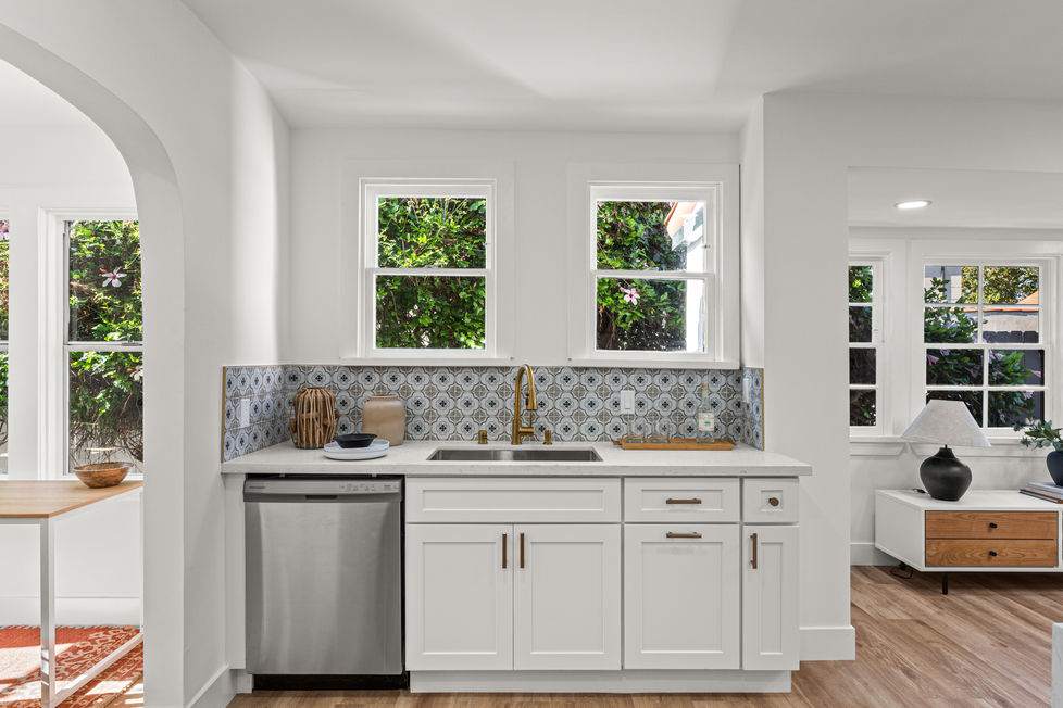a kitchen with white cabinets and a stainless steel dishwasher